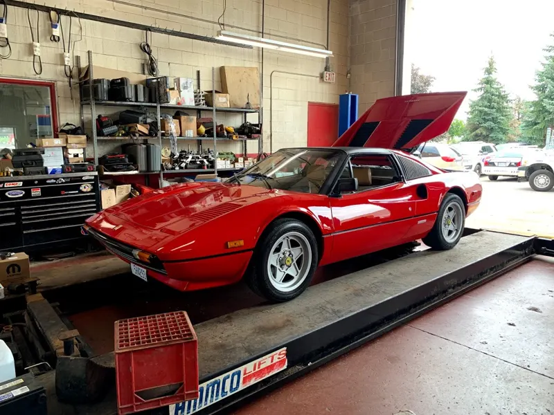 A red Ferrari on a lift in the York Auto shop