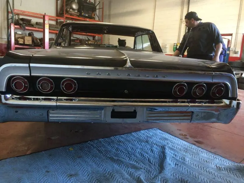 A technician working on a classic Impala